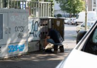 man in blue t-shirt sitting on brown wooden bench