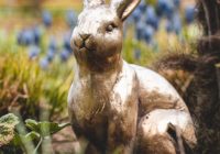 brown rabbit statue on green grass during daytime