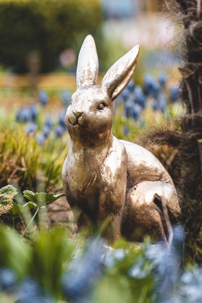 brown rabbit statue on green grass during daytime